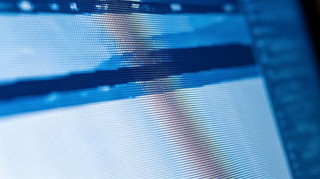 Extreme macro shot of a digital LCD screen showing individual pixels in blue and white tones, creating an abstract grid pattern.