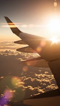 airplane wing above clouds close-up side view during flight with sun glare and cloud layer below, aviation travel concept with passenger aircraft cruising, journey, tourism, air transport experience