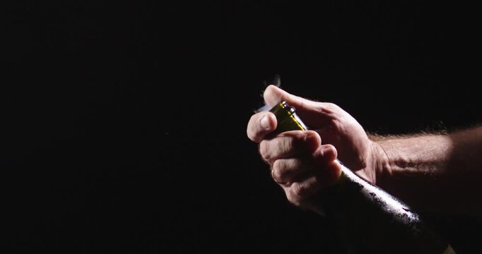 Champagne held in hand before toast. Champagne opening marks festive occasion. Champagne cork pressed under pressure. Champagne bottle opening in slow motion style.
