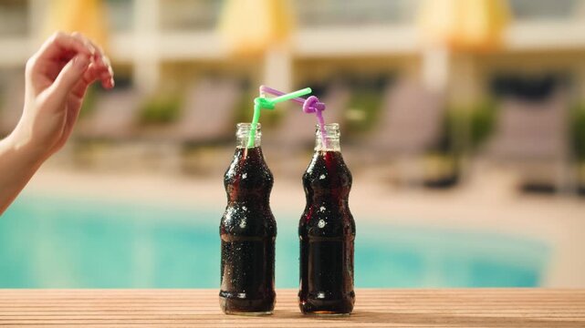 Cola opening and cheers, drinks, people and lifestyle concept - close up of happy woman drinking cola in sunset beach bar in hotel. 