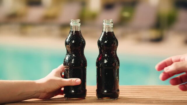 Cola opening and cheers, drinks, people and lifestyle concept - close up of happy woman drinking cola in sunset beach bar in hotel. 