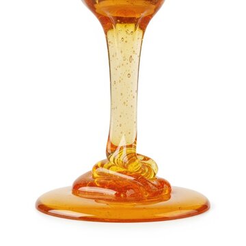 Golden viscous honey liquid flowing and dripping down from above