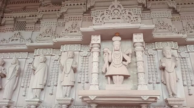 Panning Shot of Swaminarayan Bhagwan and Hindu Saint Sculptures on Temple Wall