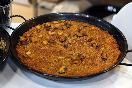paella de arroz con mariscos en la paellera reci&eacute;n elaborada preparada para servir