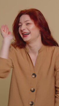 Amused redhead woman pointing finger to camera, laughing out loud, taunting making fun of ridiculous appearance, funny joke anecdote. Young ginger girl isolated alone on beige studio background