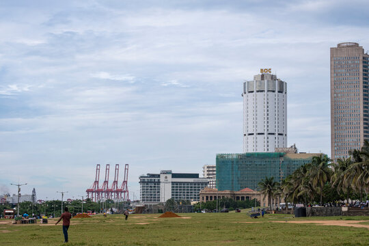 12.8.2025 Colombo, Sri Lanka.The Bank of Ceylon BOC tower and city skyline view from the green lawn park of Galle Face Green with sea port cranes in the background.