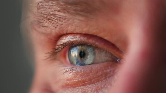 Extreme Close Up Male blue Eye Blinking And Looking Around In Dark, middle aged portrait