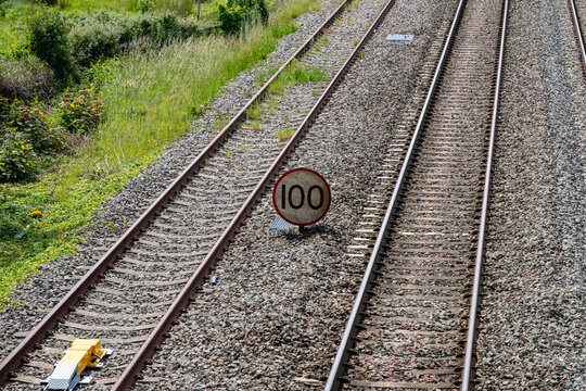 Railway main line with a 100 mph line speed sign near Ashchurch, Tewkesbury, Gloucestershire, England