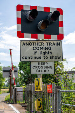 Warning sign and red signal lights at a railway level crossing in Northway, Tewkesbury, Gloucestershire