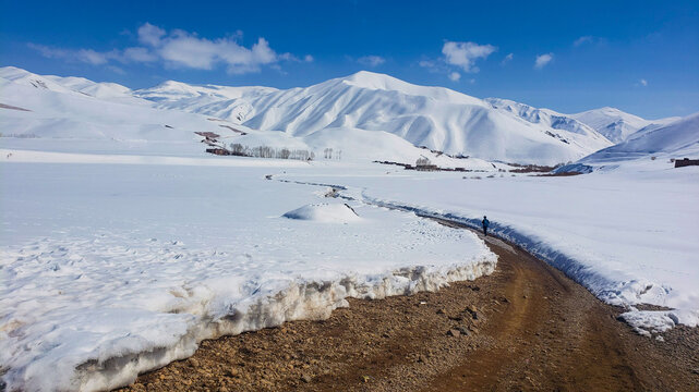 Child Walking to School Through Snow in Bamyan, Afghanistan with Blue Backpack