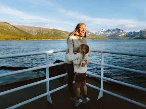 Family mother and daughter travel by ferry in Norway enjoying sea view, mom and child having fun on summer vacations tour outdoors parent and kid together happy candid emotions bonding moments