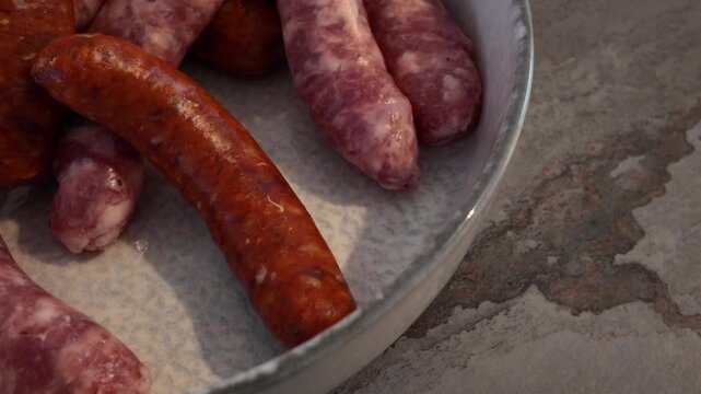 Assortment of chipolatas and merguez close-up cinematic view. Macro shot of assortment of chipolatas and merguez. Assortment of chipolatas and merguez in slow motion.