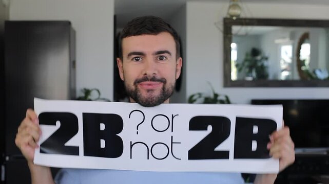 Man holding "TO BE or not TO BE" sign