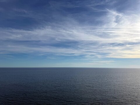 Calm sea dark blue water and cloudy sky.