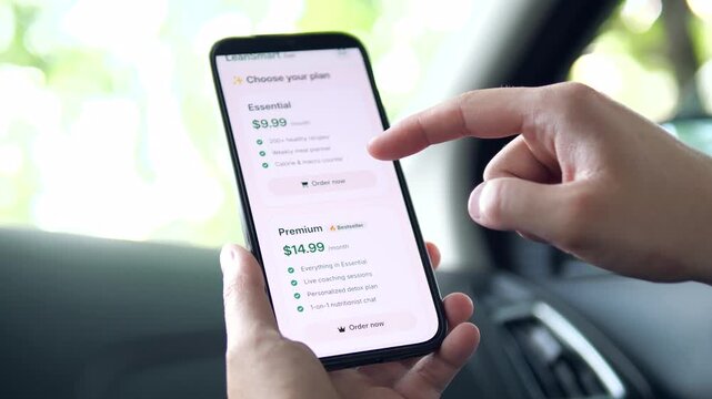 Person selecting a diet and fitness plan on a smartphone. Detailed pricing interface for meal planners and calorie counters. Ideal for health tech, wellness apps, and modern consumer behavior content