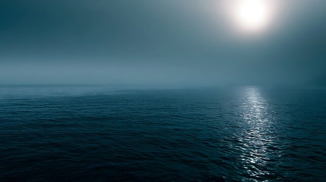 Tranquil blue sea bathed in diffused foggy light creates a serene and wanderlust inducing seascape