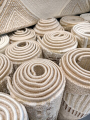 Naklejka premium Soft home carpets rolled into large rolls displayed in a supermarket offering cozy flooring solutions for modern residential interiors