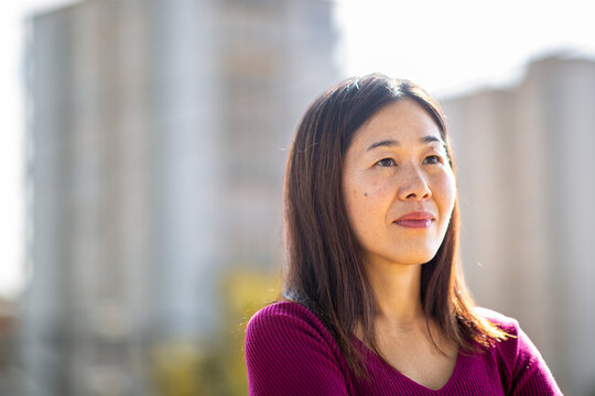 Asian woman standing confidently in urban setting