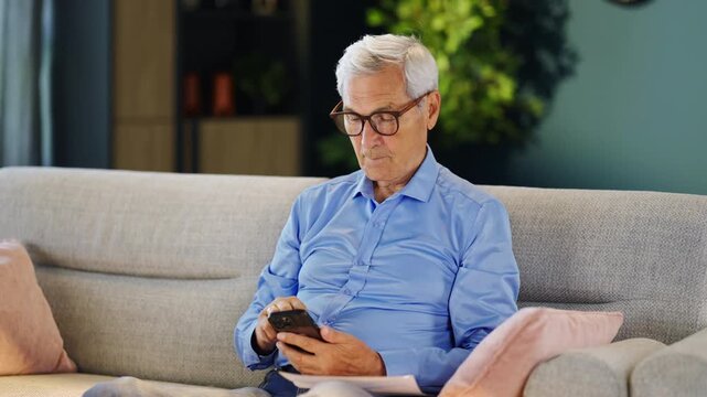 Older adult reviewing a utility bill while making an online payment through a smartphone banking application. Personal finance and digital technology.