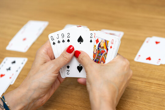 Woman's hands holding a fan of playing cards &mdash; card game, leisure, entertainment