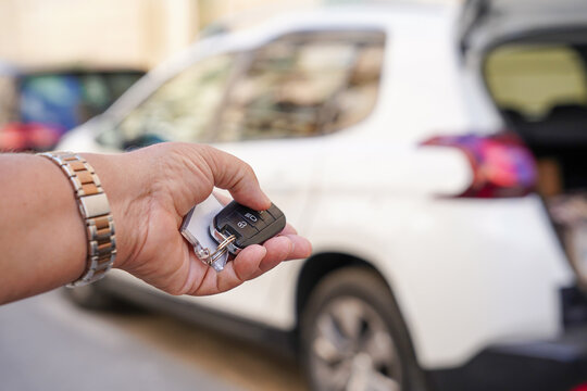 Car key in hand near vehicle during travel