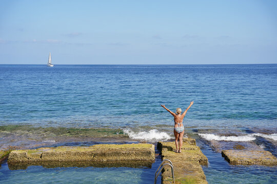 Senior woman relaxing in natural seaside pool