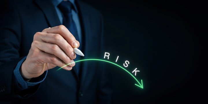 Businessman drawing a downward arrow with a white pen, illustrating the concept of risk reduction and business improvement.