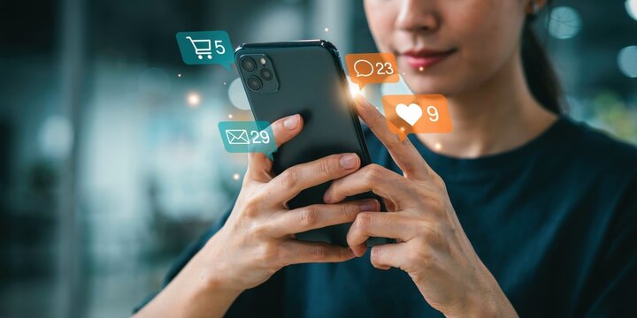 Young woman holding smartphone with floating digital social media icons representing engagement and notifications.