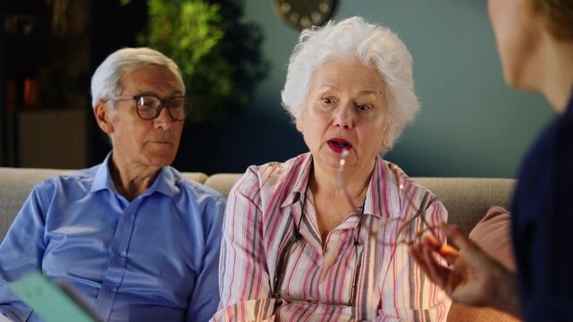 An older couple talks with a care coordinator about home care services. They review a list of options and discuss their needs for support at home.