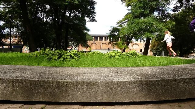 Time lapse 2 little sisters run on a concrete parapet in a summer city park.Smolensk, Russia.