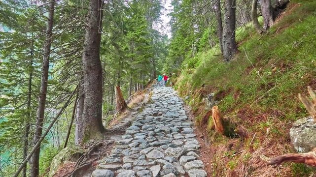 Two girls walking on the stone path around Lake Morskie Oko near Zakopane, Poland.