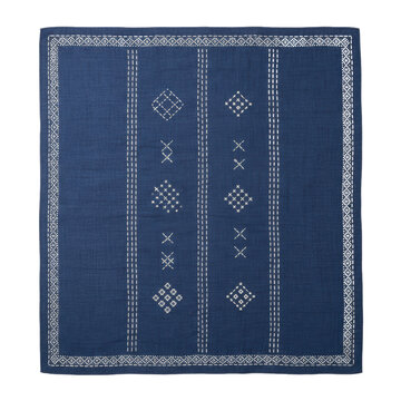 Indigo blue hand-woven tapestry with white geometric embroidery on flat white background, top-down view showing tactile fabric grain, artisanal craft atmosphere