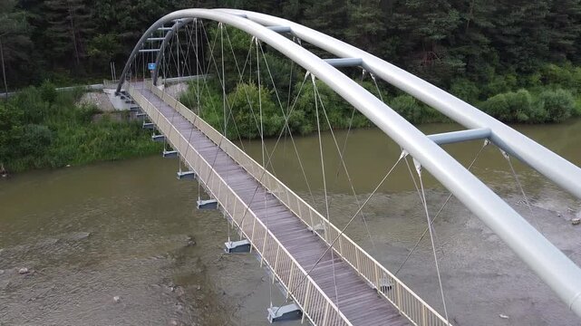 Aerial view of EuroVelo 11 bike path along Poprad river in summer, drone shot of scenic cycling route between Krynica-Zdroj, Muszyna and Rytro in Beskid Sadecki mountains, Poland.