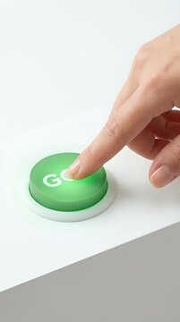 Caucasian hand pressing green go button on white surface for business, technology, and decision-making concepts.