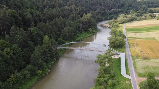 Aerial view of EuroVelo 11 bike path along Poprad river in summer, drone shot of scenic cycling route between Krynica-Zdroj, Muszyna and Rytro in Beskid Sadecki mountains, Poland.