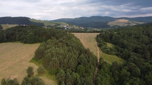 Aerial view of EuroVelo 11 bike path along Poprad river in summer, drone shot of scenic cycling route between Krynica-Zdroj, Muszyna and Rytro in Beskid Sadecki mountains, Poland.