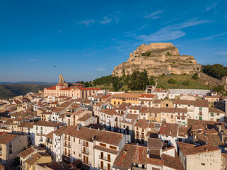 Fototapeta premium Elevated view over Morella's terracotta rooftops with the Gothic church of Santa Maria and hilltop castle, Els Ports, Castellon, Valencian Community, Spain
