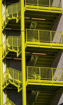 Bight Yellow Exterior Staircase on a Grey Building.