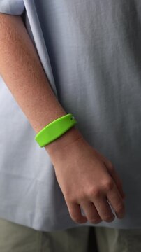 A teenager in a hotel room puts on an RFID or NFC bracelet. A boy puts on a contactless bracelet on his wrist. High quality FullHD footage