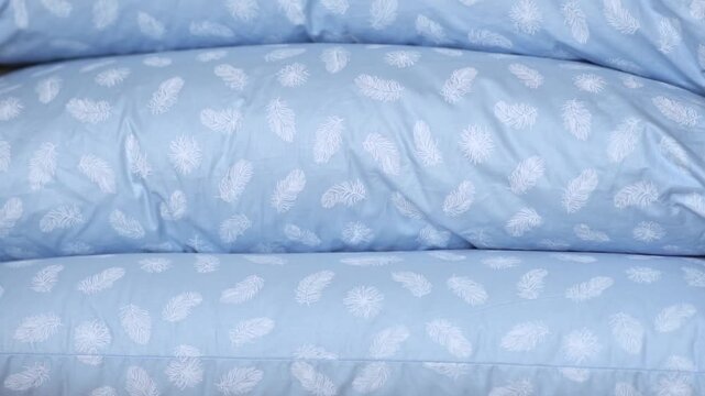 A stack of new down pillows. Clean, soft pillows for sleeping and relaxing, made of natural down and feathers. High quality FullHD footage