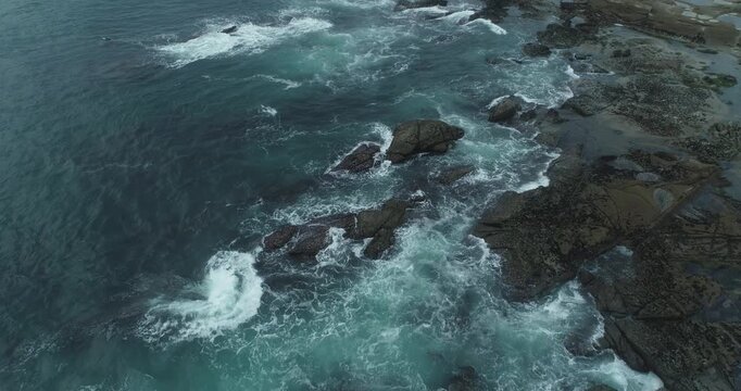 Powerful marine landscape capturing the raw energy of waves impacting against a jagged stone coast