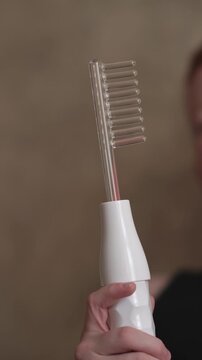 A teenager uses a Darsonval device. Professional skincare at home. Teenage skin issues during hormonal changes. High quality FullHD footage