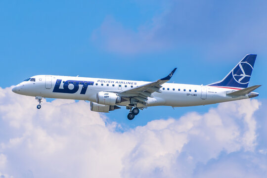 LOT Polish Airlines Embraer 190 passenger jet, registration SP-LMH, descending for landing against a cloudy sky.