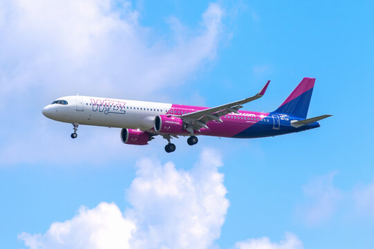 Wizz Air Airbus A321neo passenger jet, registration HA-LDI, descending for landing in the sky with clouds.