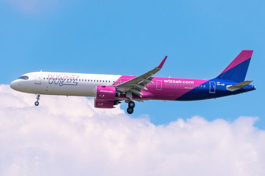 Wizz Air Airbus A321neo passenger jet, registration HA-LDI, descending for landing in the sky with clouds.