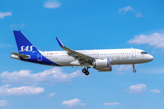SAS Scandinavian Airlines passenger jet, registration EI-SIY, descending for landing against a clear blue sky.