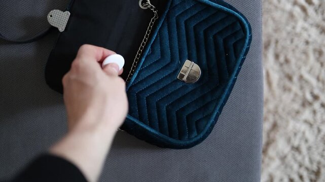 Close up of a person secretly placing a GPS tracker inside a handbag illustrating covert surveillance stalking risks privacy violations and unauthorized location monitoring