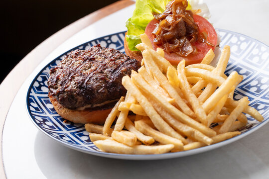 Grilled Beef Burger Served with Crispy French Fries and Fresh Toppings
