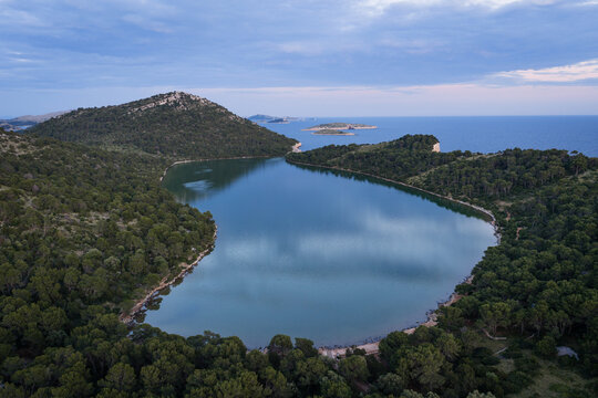 Tranquil twilight aerial view of Lake Mir surrounded by pine forests in Telascica Nature Park, Croatia