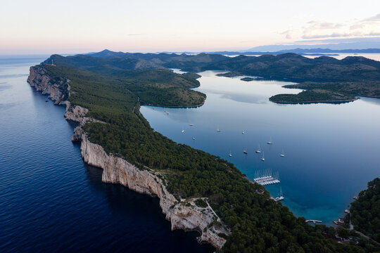 Calm morning aerial view of yachts anchored in Telascica bay and steep coastal cliffs, Dugi Otok island, Croatia